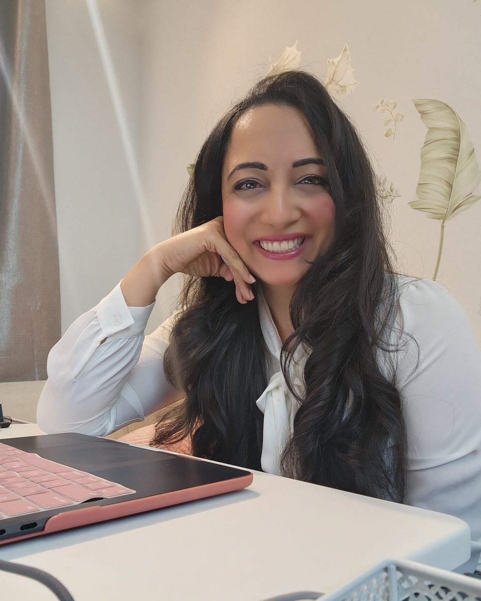 Nadia Quraishi, Holistic Nutritionist, smiling at her desk